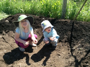 The kids crouching in what will soon grow into their garden hide out.